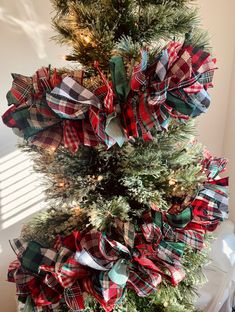 a christmas tree decorated with red, green and blue plaid bows