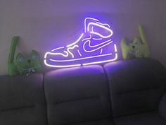 a neon light up shoe is sitting on a couch next to two small stuffed animals