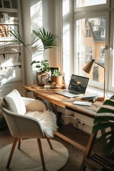 a laptop computer sitting on top of a wooden desk next to a chair and potted plant