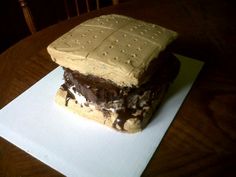 a piece of cake sitting on top of a white paper covered in chocolate frosting