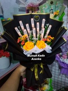 an arrangement of flowers is being held up by someone's hand with the words rumma kado azenka on it