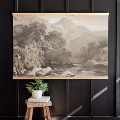 a painting hanging on the wall next to a potted plant