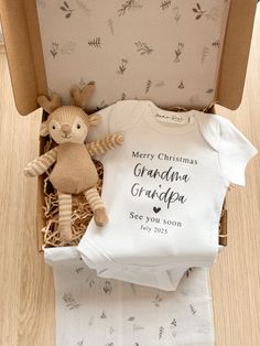 a baby's first christmas gift box with a teddy bear and t - shirt