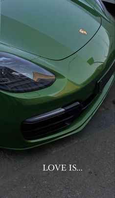 the front end of a green sports car with a love is written on it's hood