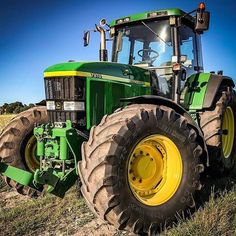 a green tractor parked on top of a grass covered field