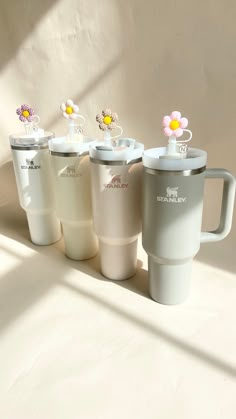 four coffee mugs with flower decorations on them