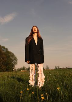 a woman standing in the middle of a field