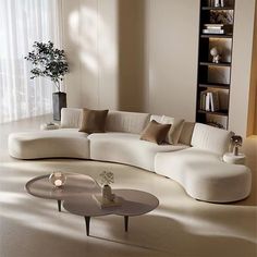 a living room filled with white furniture next to a tall book shelf full of books