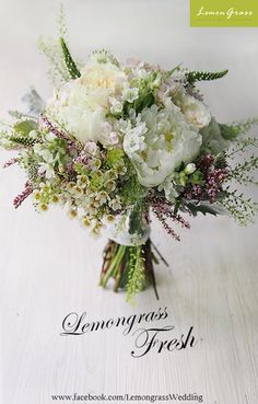 a bouquet of white flowers sitting on top of a wooden table with the words lemongrass fresh