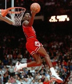 a basketball player dunking the ball into the hoop in front of an arena full of people