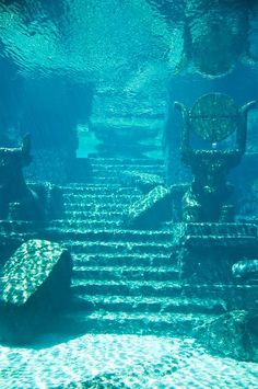 an underwater view of some stairs and chairs