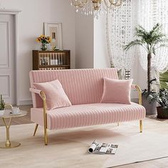 a living room with a pink couch and chandelier