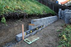 there is a large pile of cement blocks in the yard with measuring tape on it