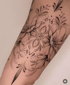 a woman's leg with black and white flowers on the side of her body