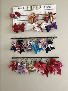 there are several bows hanging on the wall next to each other, and one has a sign that says it's a cheer