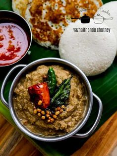 some food is on a green plate with sauces and other foods in bowls next to it