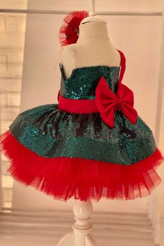 Allison is one of our beautiful Christmas dresses. Fabric: Sequin fabric, Satin bow detail, Dream tulle, Crystal tulle, Cotton lining. Emerald Green sequin dress Sleeveless dress Bow ribbon on the front of the dress Illusion collar Special red satin belt across the right shoulder connecting the two bows Red satin bow on the back of the dress Red satin belt around the waist Knee-length and full crinoline Hair Accessory included Suggestions for the use of Allison Green Party Dress Christmas dress Allison Green, Emerald Green Sequin Dress, Silver Flower Girl Dress, Party Dress Christmas, Toddler Girl Christmas Dresses, Girls Gold Dress, Red Green Dress, Purple Flower Girl Dress, Girl Green Dress