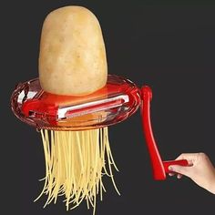 a spaghetti dish being held up by a red handled hair dryer with noodles attached to it