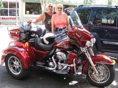 two women are sitting on a red motorcycle