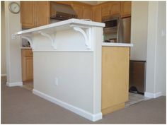 an empty kitchen with white counter tops and wooden cabinets in the backround area