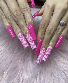 two hands with pink and white nail designs on them