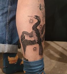 a man's leg with a bird tattoo on it