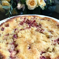 a close up of a pie on a plate with flowers in the backgroud