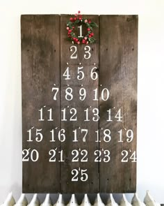 a wooden sign with numbers on it sitting next to a white radiator and red berries