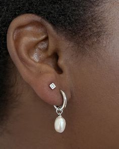 Classy and chic, we’re obsessed with the Willa Silver Pearl Huggie Earrings in White Pearl—and you will be, too! A dainty cultured freshwater pearl dangles from a petite huggie for a lightweight style you’ll pair back with any stack. Metal Rhodium Over Brass Material White Pearl Closure Ear Post Size 1.8" Outside Diameter, 0.4"L X 0.3"W CharmDue to the one-of-a-kind nature of the medium, exact colors and patterns may vary slightly from the image shown. | Kendra Scott Willa Silver Pearl Huggie Ea Dainty Dangle Earrings Silver, Small Dangly Silver Earrings, Silver Earrings Classy, Double Piercing Earrings Studs, Classy Stud Earrings, Simple Wedding Earrings Silver, Trendy Earrings Silver, Beachy Jewelry Silver, Silver Earring Stack 3 Holes