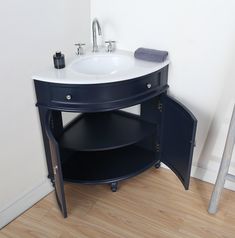 a white sink sitting next to a blue cabinet on top of a hard wood floor