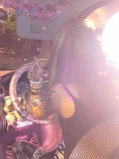 a woman sitting in the back seat of a car next to a basket filled with stuff