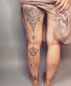 a woman's legs with tattoos on them and an object in the bottom right corner