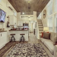 a living room filled with furniture and a flat screen tv mounted to the side of a wall