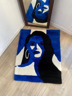 a blue rug with a woman's face on it in front of a mirror