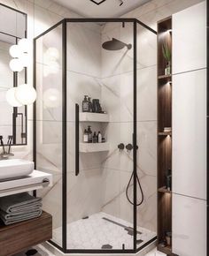 a bathroom with a walk in shower next to a white sink and wooden shelves on the wall