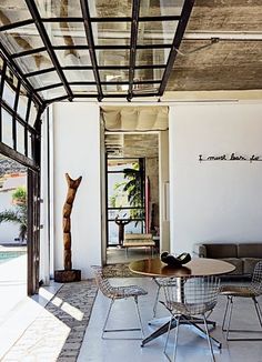 a living room filled with furniture next to a swimming pool on top of a tiled floor