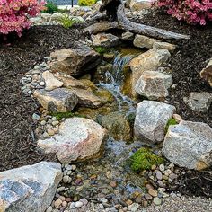 a garden with rocks and water running through it