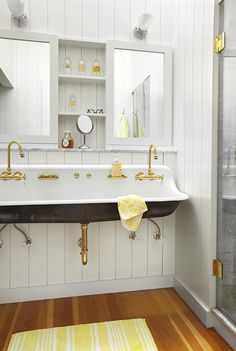 a bathroom with white walls and wooden floors