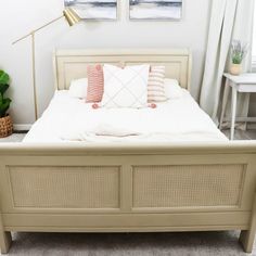 a bed with white sheets and pillows in a room