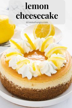 a lemon cheesecake with whipped cream and sliced lemons on top, sitting on a white plate