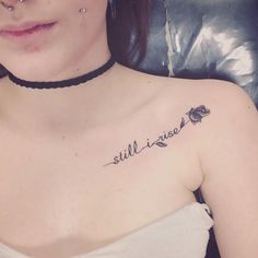 a woman with a tattoo that says still i rise on her left chest and the words still i rise written in cursive font