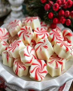 a white plate topped with red and white peppermint candy canes on top of a table