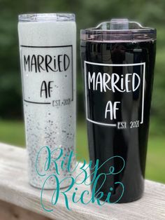 two black and white tumblers sitting on top of a wooden table next to each other