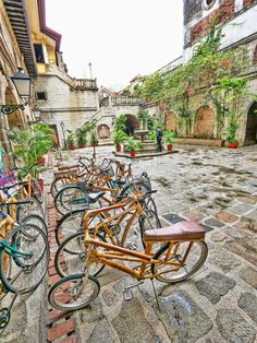 there are many bikes that are parked on the street together in front of some buildings