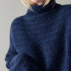 a woman with blonde hair wearing a blue sweater