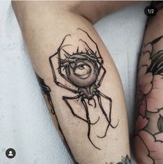 a spider tattoo on the leg of a woman