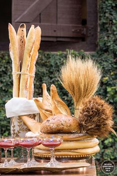 bread and wine are sitting on a table with an assortment of breads in front of it