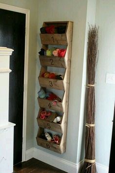 a wall mounted shoe rack in the corner of a room next to a fireplace and door