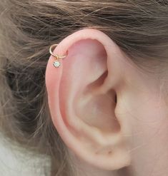 a close up of a person's ear with a small diamond on it,