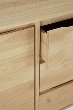 a close up of a wooden cabinet with two drawers and one door open on the side